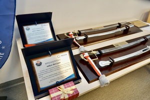 tabliczki oraz szable dla odchodzących na emeryturę policjantów